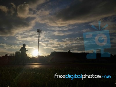 Silhouette  Running On Road At Sunrise Stock Photo