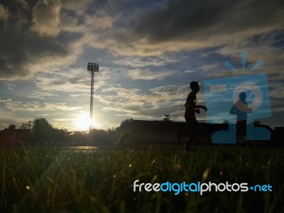 Silhouette  Running On Road At Sunrise Stock Photo