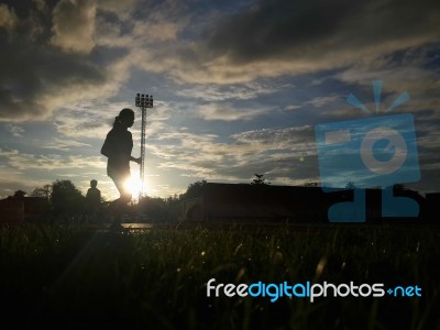 Silhouette  Running On Road At Sunrise Stock Photo