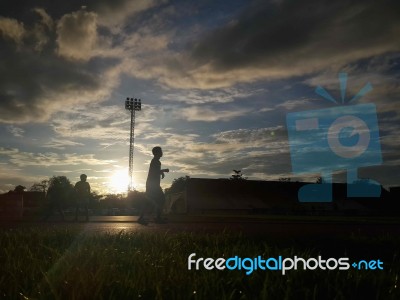 Silhouette  Running On Road At Sunrise Stock Photo