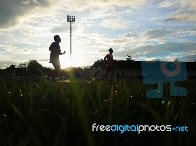 Silhouette  Running On Road At Sunrise Stock Photo