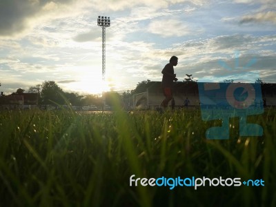 Silhouette  Running On Road At Sunrise Stock Photo