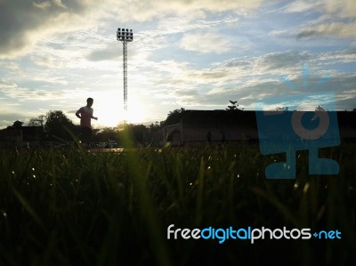 Silhouette  Running On Road At Sunrise Stock Photo