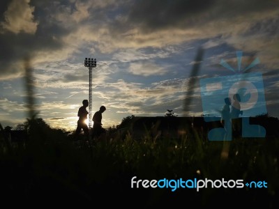 Silhouette  Running On Road At Sunrise Stock Photo