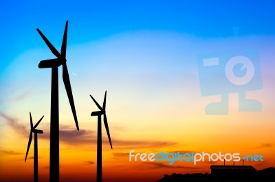 Silhouette Wind Turbine Generator With Factory Emissions Of Carb… Stock Photo