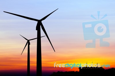 Silhouette Wind Turbine Generator With Factory Emissions Of Carb… Stock Photo