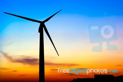 Silhouette Wind Turbine Generator With Factory Emissions Of Carb… Stock Photo