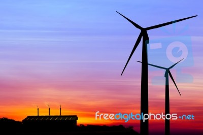 Silhouette Wind Turbine Generator With Factory Emissions Of Carb… Stock Photo