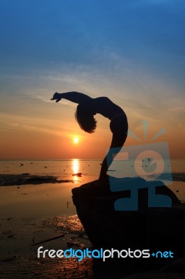 Silhouette Yoga Girl By The Beach At Sunrise Stock Photo