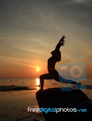 Silhouette Yoga Girl By The Beach At Sunrise Stock Photo