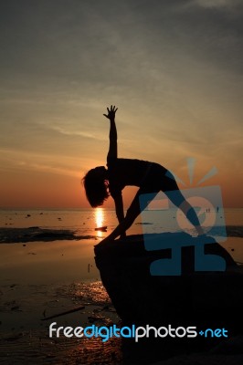 Silhouette Yoga Girl By The Beach At Sunrise Stock Photo