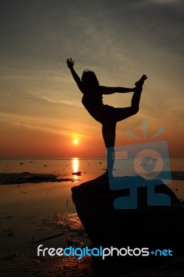 Silhouette Yoga Girl By The Beach At Sunrise Stock Photo