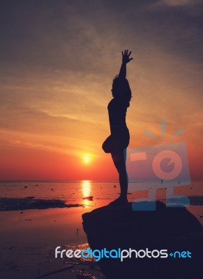 Silhouette Yoga Girl By The Beach At Sunrise Stock Photo