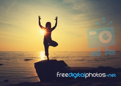 Silhouette Yoga Girl By The Beach At Sunrise Stock Photo