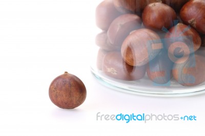 Single Roasted Chestnuts Outside Bottle On White Floor Stock Photo