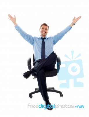 Sitting Businessman Arms Raised Stock Photo