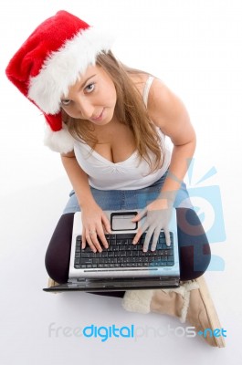 Sitting Female Wearing Christmas Hat And Holding Laptop Stock Photo