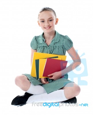 Sitting Schoolgirl Holding Books Stock Photo