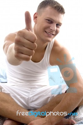 Sitting Young Man Showing Thumb Up Stock Photo