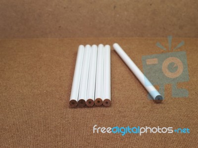 Six Unsharpened White Pencils On Wooden Board Stock Photo