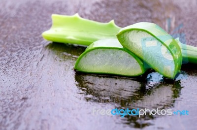 Slice Aloe Vera On Wet Wood Background Stock Photo