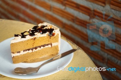 Slice Of Coffee Cake On Dish On The Wooden Table Stock Photo