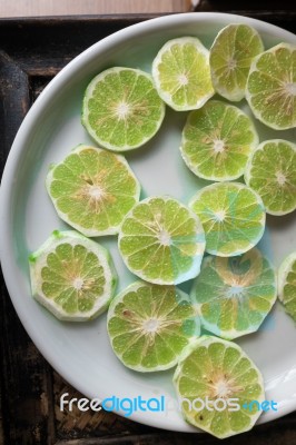 Slice Of Peeled Green Fresh Lime On White Plate Stock Photo