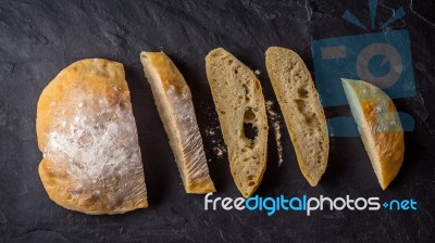 Sliced Ciabatta On The Dark Stone Table Top View Stock Photo