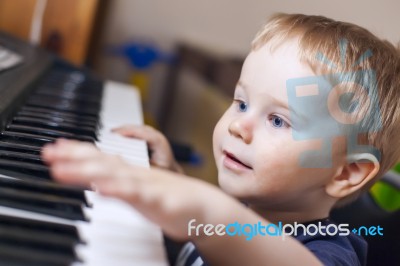 Small Boy Enjoys Playing Electric Piano Stock Photo