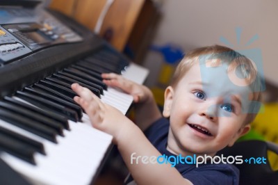 Small Boy Enjoys Playing Electric Piano Stock Photo