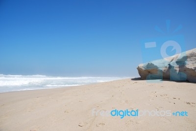 Small Cliff At A Beautiful Beach In Praia Del Rey Stock Photo