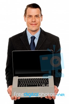 Smart Businessman Displaying Laptop To You Stock Photo