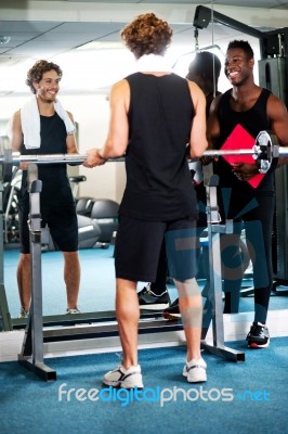 Smart Young Guy Lifting Barbells In Gym Stock Photo