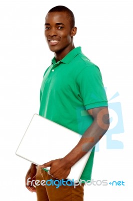 Smiling African Guy Carrying Laptop Stock Photo