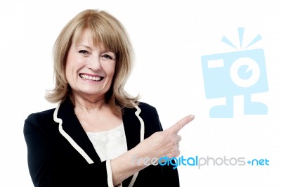 Smiling Aged Woman Pointing Away Stock Photo