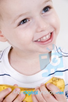 Smiling Boy Holding Banana Stock Photo