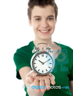 Smiling Boy Showing Alarm Clock Stock Photo