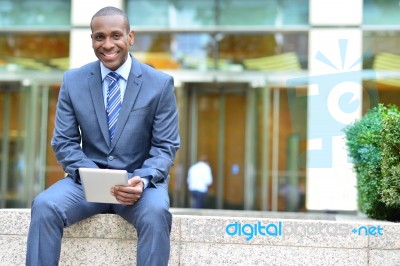 Smiling Business Executive Using Tablet Stock Photo