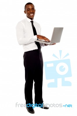 Smiling Businessman Holding Laptop Stock Photo