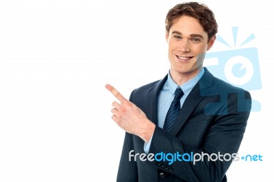 Smiling Businessman Pointing Away Stock Photo