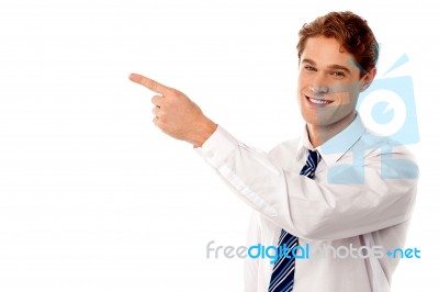 Smiling Businessman Pointing Away Stock Photo