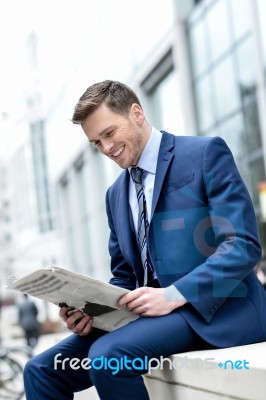 Smiling Businessman Reading Paper At Outdoors Stock Photo