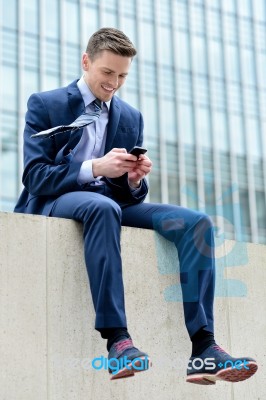 Smiling Businessman Using His Smartphone Stock Photo