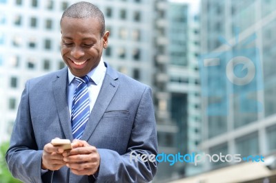 Smiling Businessman Using His Smartphone Stock Photo