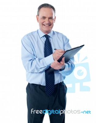 Smiling Businessman With Clipboard Stock Photo