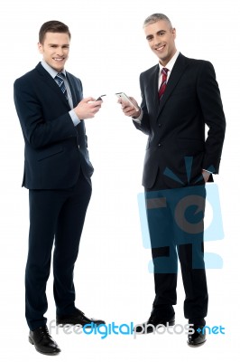 Smiling Businessmen Using Cellphone Stock Photo