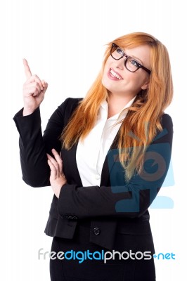 Smiling Businesswoman Pointing Upwards Stock Photo