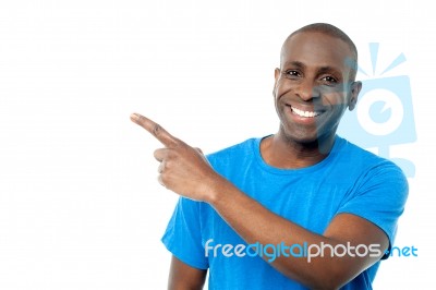 Smiling Casual Man Pointing Away Stock Photo