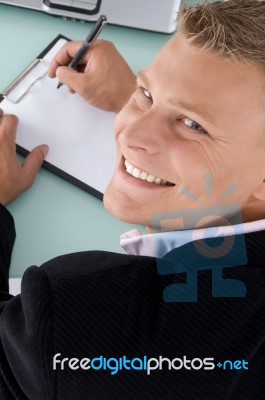 Smiling Ceo Writing on clipboard Stock Photo