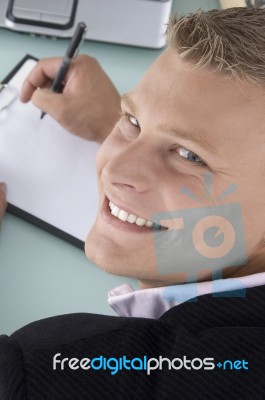 Smiling Ceo Writing on clipboard Stock Photo